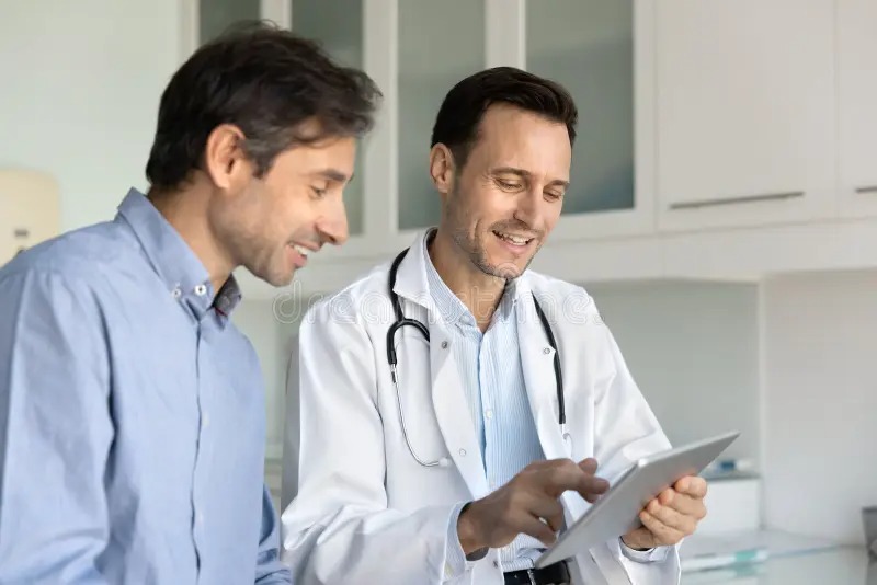 Patient accessing digital health records on a tablet while consulting a doctor.