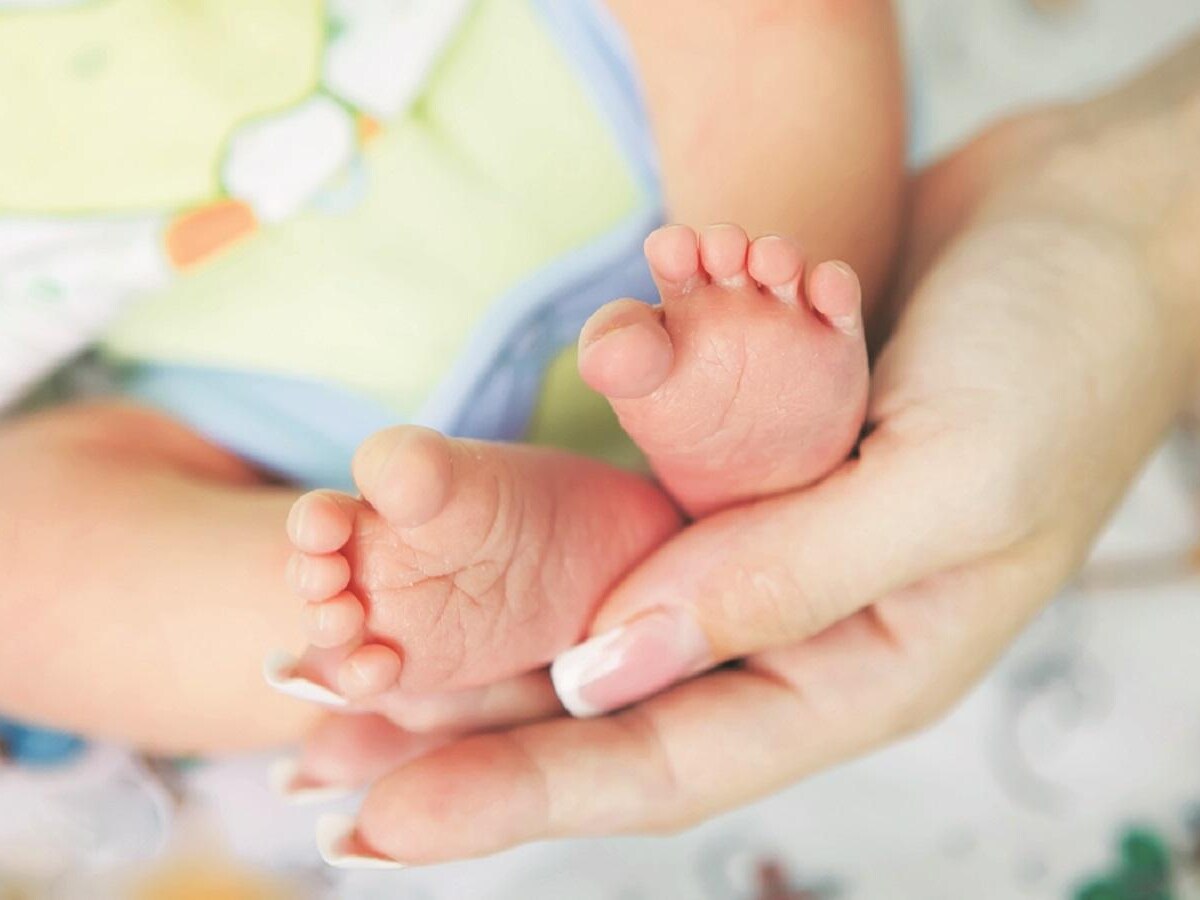 Parents securing newborn health insurance through Vizzve Finance app.