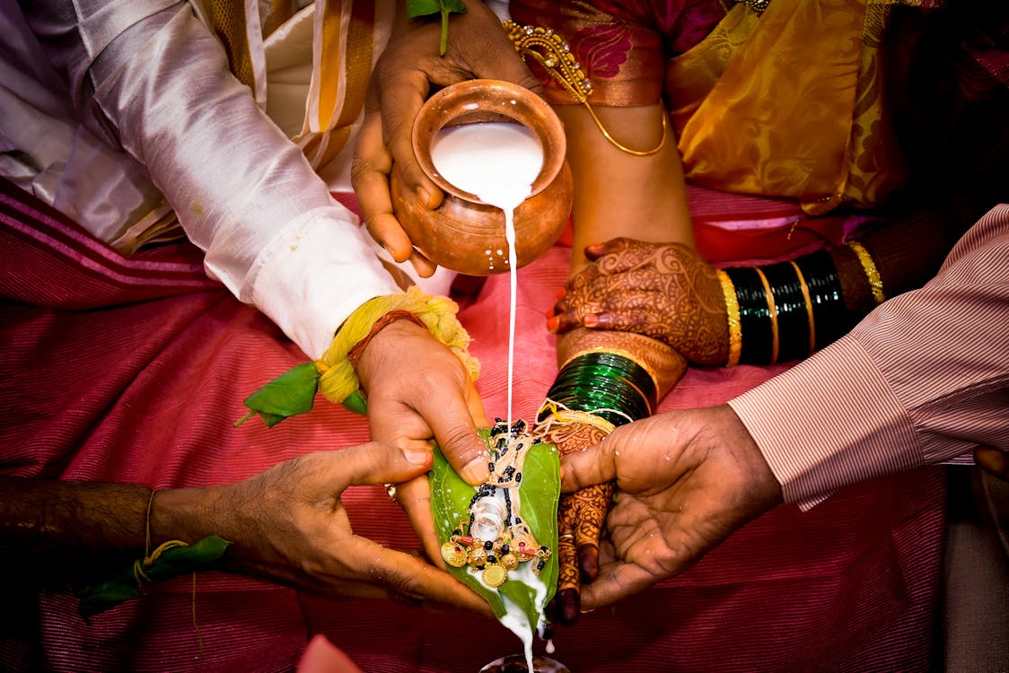 Newlywed couple holding hands at a traditional Indian wedding