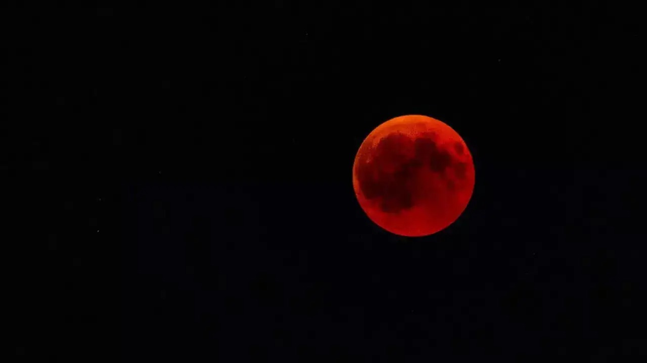 Total lunar eclipse visible in the night sky with red moon