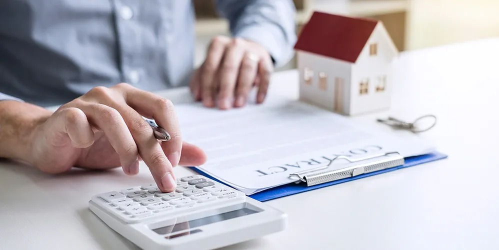 Person calculating home loan EMI during falling interest rates