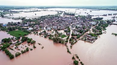 Flooded village in Punjab with swollen Beas and Sutlej rivers in the background