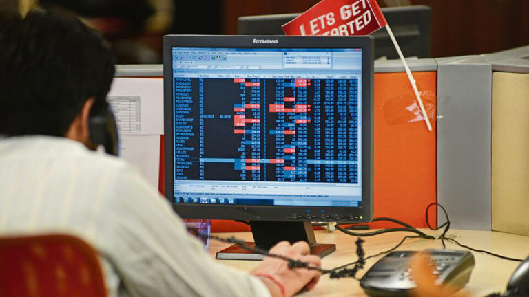 Indian stock market screen showing Sensex and Nifty with mixed trends.