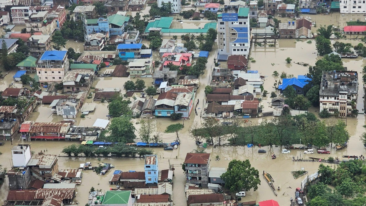 Residents navigating flooded streets in Manipur following heavy rainfall on September 14, 2025.