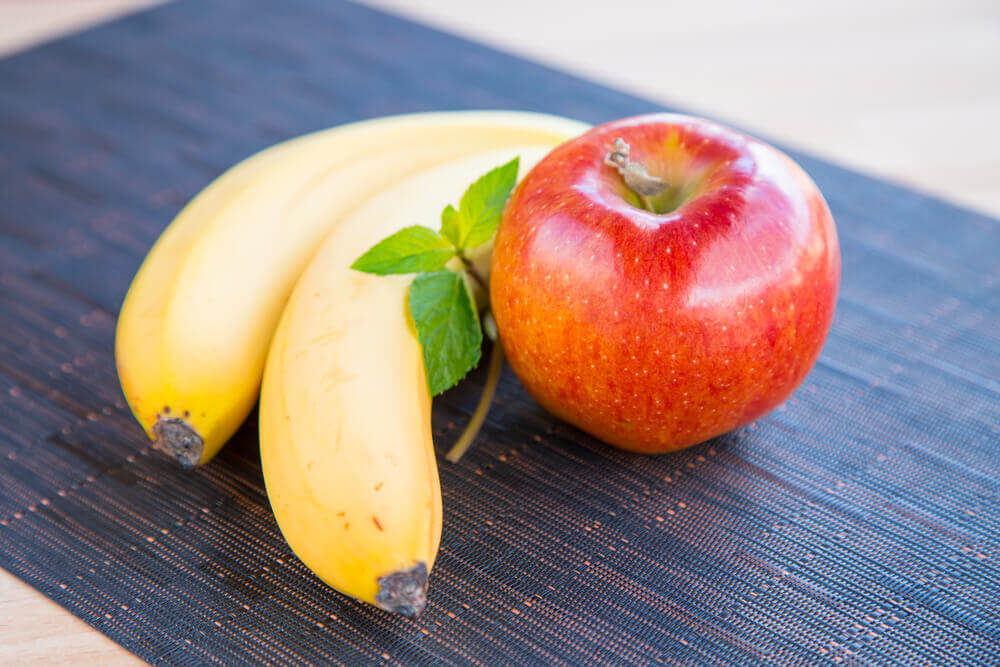 Banana and apple on a plate for weight loss comparison