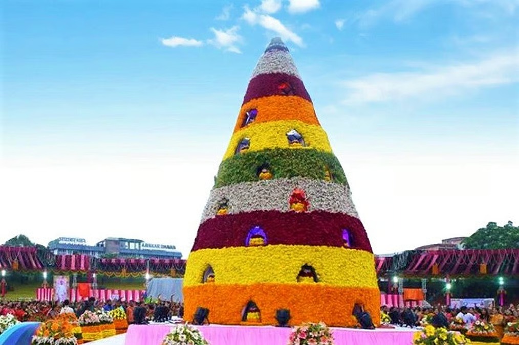 Women celebrating Bathukamma festival with colorful floral arrangements during grand parade in Telangana