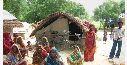 Anganwadi worker standing near unused LED TV in rural Madhya Pradesh due to lack of electricity.