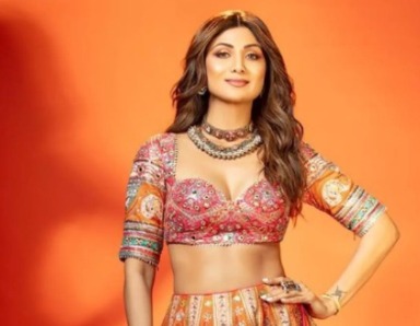 Shilpa Shetty attending a Bollywood film event with financial graphics overlay