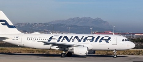 Finnair airplane on runway with delayed flights signage