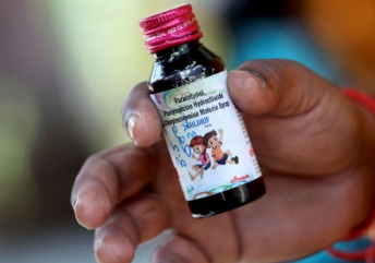 Cough syrup bottles with warning sign, representing Coldrif case