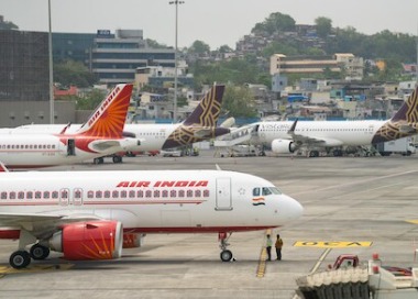 Air India aircraft parked at the airport with winter travel passengers boarding.