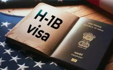 Indian IT professionals working on laptops with US flag and H-1B visa documents.