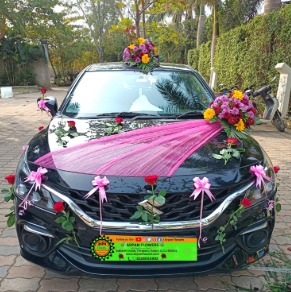 Happy family taking delivery of a new car decorated with flowers during Diwali celebration.