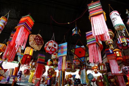 Diwali market with shoppers and festival decorations.