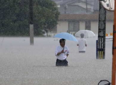 Flooded Indian street during monsoon with people wading through rainwater — symbolizing extreme rainfall and climate change