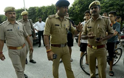 Police van with shattered windows after villagers threw stones in Uttar Pradesh, cops attending the scene