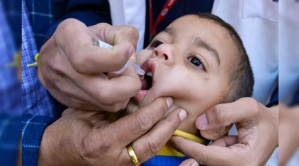 Healthcare worker administering polio vaccine drops to a child in India on World Polio Day
