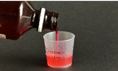 Pharmacist testing cough syrup samples in a government laboratory