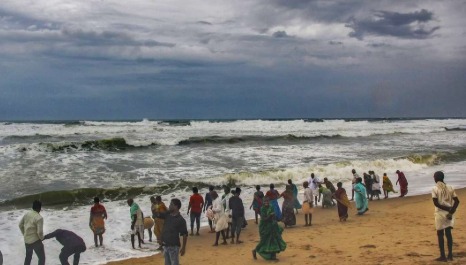 Cyclone approaching Odisha coast with heavy clouds and waves.