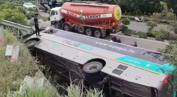 Overturned bus on Telangana highway with rescue teams at the site.