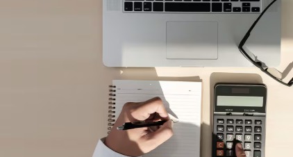 A person managing multiple personal loan payments on a laptop with financial charts