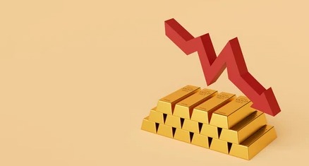Gold bars and coins with downward arrow indicating price fall