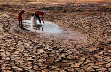 Cracked dry earth and flooded village symbolizing climate challenges faced by developing nations