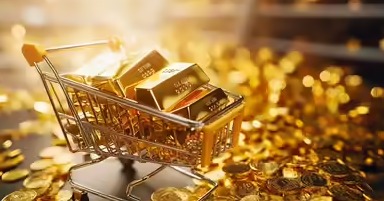 Investor analyzing falling gold prices on screen with gold bars and coins on desk