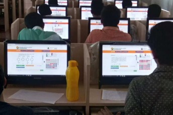 Students appearing for JEE Main exam at computer-based test centre with NTA branding.