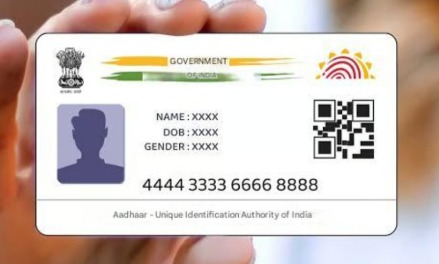 Aadhaar card with a fingerprint scanner and UIDAI logo, symbolizing new Aadhaar rule updates effective November 1, 2025