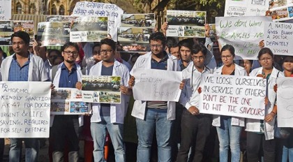 Doctors in white coats holding placards during a protest in Maharashtra demanding better working conditions.
