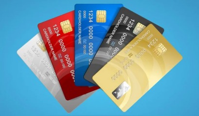 Person calculating credit card bills while considering a personal loan for repayment