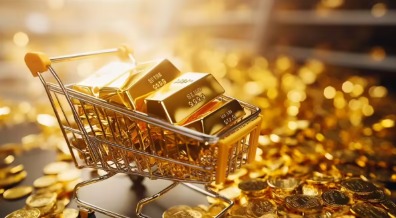 Gold bars and coins displayed on a financial newspaper showing daily gold rates