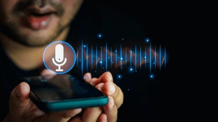 A person speaking into a smartphone, symbolizing AI voice authentication for digital loan verification in India.