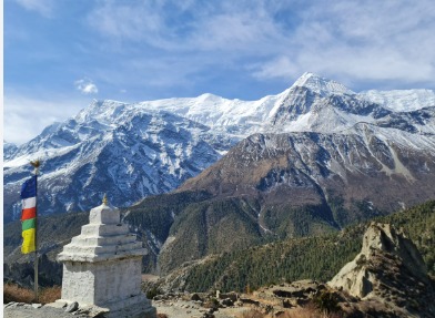 Trekkers walking on the snowy Annapurna Circuit trail in Nepal, surrounded by towering Himalayan peaks.