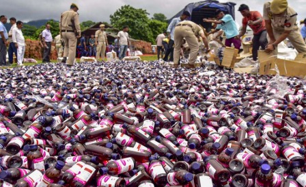 Police officials displaying seized bottles of banned cough syrup during a raid in Ghaziabad.
