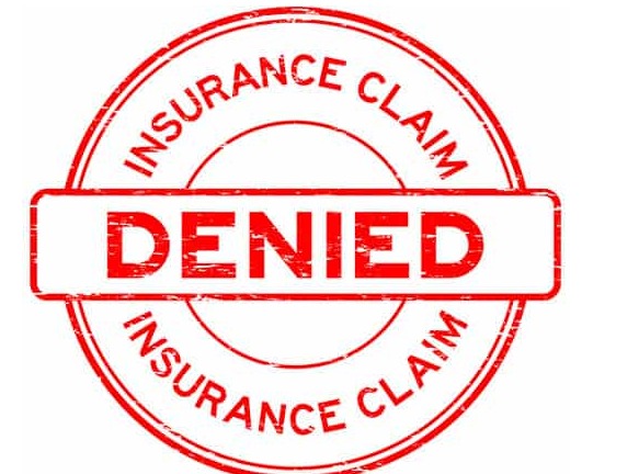 Hospital bills and health insurance claim form with a stamp “REJECTED” — representing an insured person challenging claim denial