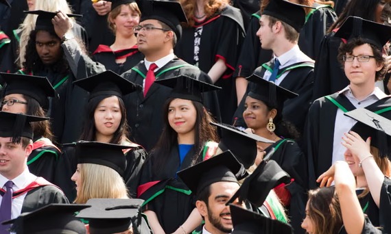 Indian students with luggage and graduation caps, highlighting concerns over reduced post-study work visa duration in the UK.