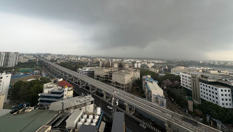 Alt-text (alt key): “Light rainfall over Bengaluru cityscape on a cloudy Friday afternoon”