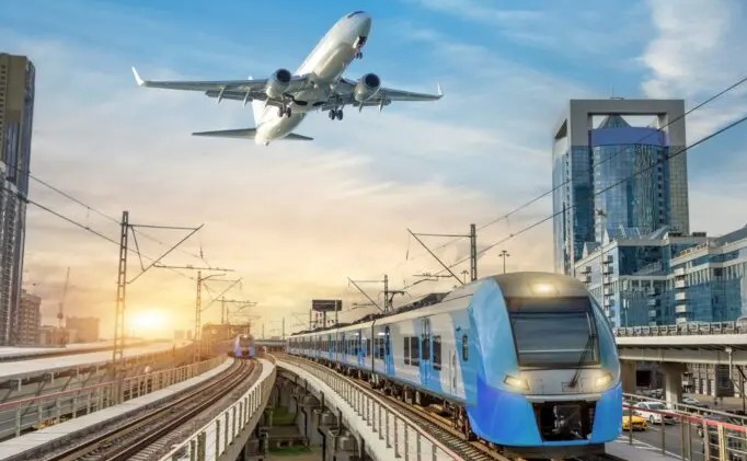 High-speed electric train on elevated tracks contrasted with an airplane taking off — representing the dual challenge of infrastructure and emissions in modern transport.