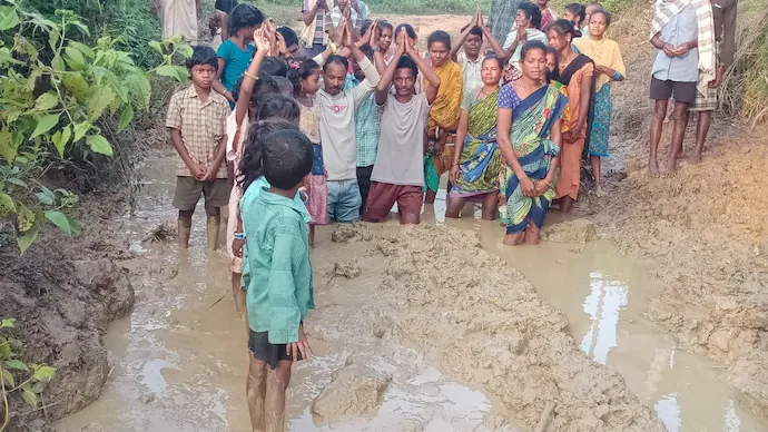 Tribal villagers in Andhra Pradesh walking through muddy paths demanding road connectivity