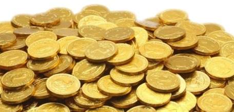 Gold bars and coins displayed with price tags showing 18K, 22K and 24K rates in India.