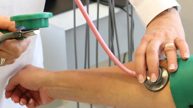 A teenage boy undergoing a blood pressure check at a clinic, representing rising hypertension among teens.