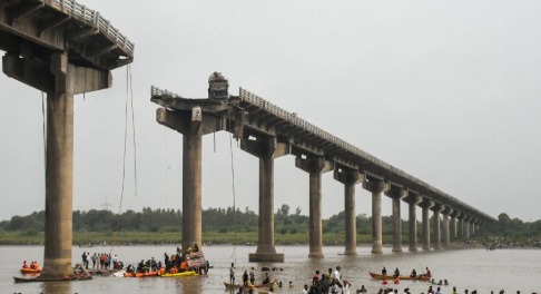 A damaged under-construction jetty in Gujarat with safety personnel inspecting the collapse site.