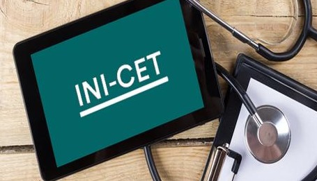 Medical postgraduate students looking at result notification board of INI-CET 2026.