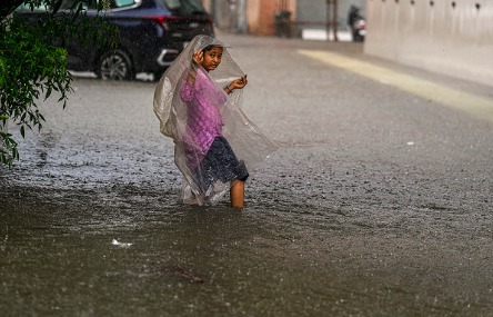 People with umbrellas walking on wet Chennai roads during heavy rainfall alert