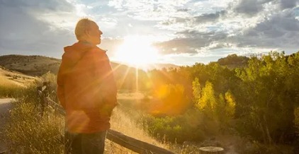 Person standing in mild sunlight with a warm glow, symbolizing Vitamin D absorption