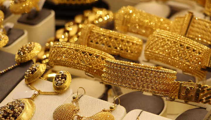 Gold and silver bars with market trend graph showing decline due to Fed minutes and strong US dollar.