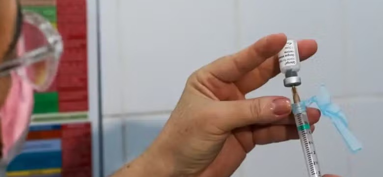 Health worker holding vial of newly approved single-dose dengue vaccine in Brazil