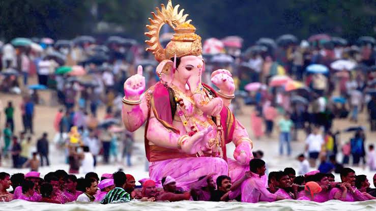 Ganesh Chaturthi 2026 celebrations in India featuring a decorated Lord Ganesha idol, devotees, flowers, traditional decorations and festive lights